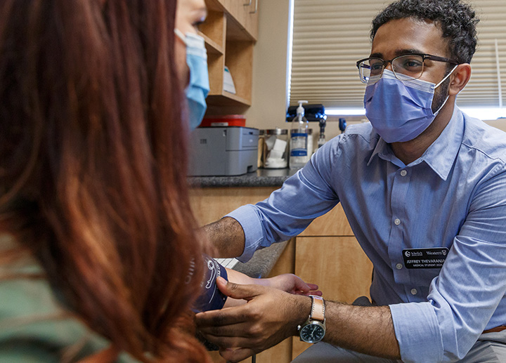 A doctor in a family clinic taking a patient's blood pressure